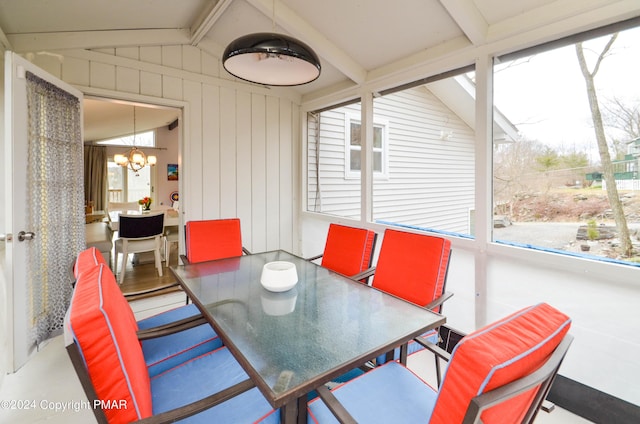 sunroom with a notable chandelier and vaulted ceiling with beams