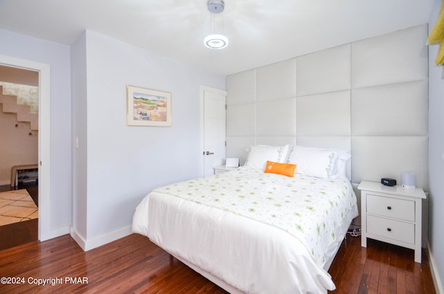 bedroom with baseboards and wood finished floors