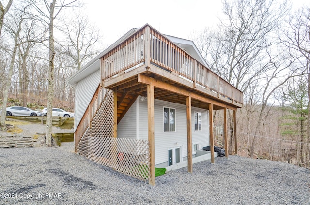 view of side of property with driveway and a wooden deck