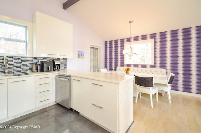 kitchen with vaulted ceiling with beams, a peninsula, a sink, light countertops, and wallpapered walls