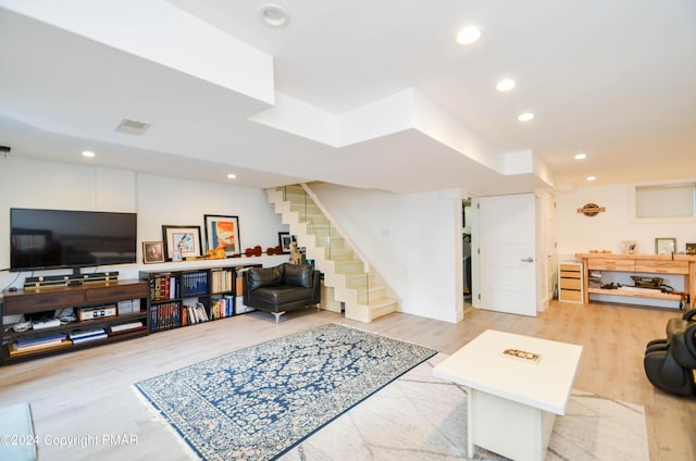 living area with light wood-style floors, recessed lighting, visible vents, and stairway