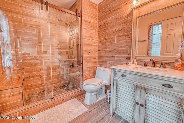 full bathroom featuring toilet, a stall shower, wood finished floors, wooden walls, and vanity