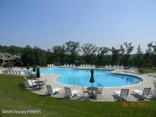 pool with a patio and a yard