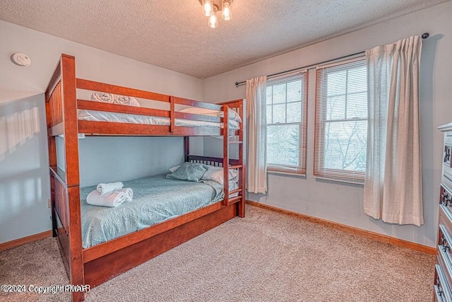 bedroom with carpet flooring, baseboards, and a textured ceiling