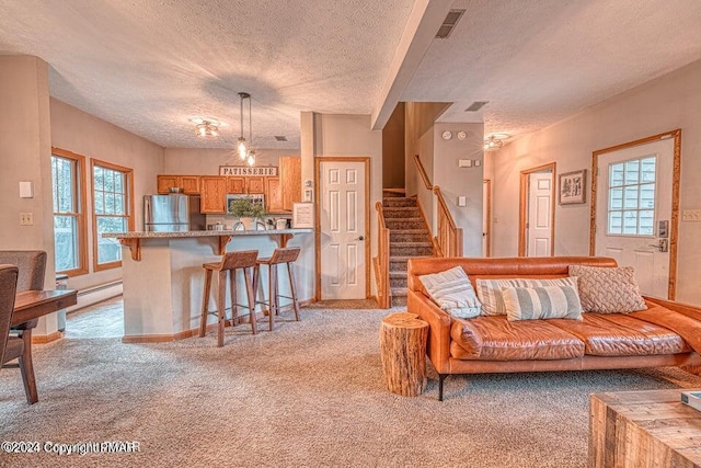 living room featuring a wealth of natural light, stairway, light colored carpet, and visible vents