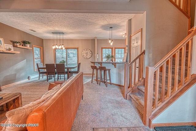 interior space with visible vents, carpet, stairs, an inviting chandelier, and a textured ceiling