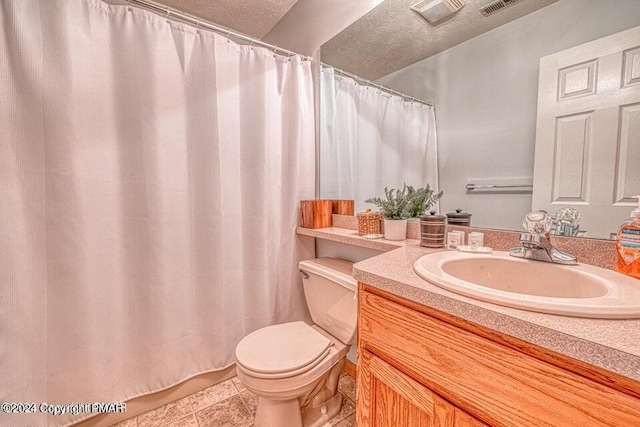 bathroom featuring tile patterned flooring, a textured ceiling, toilet, and vanity