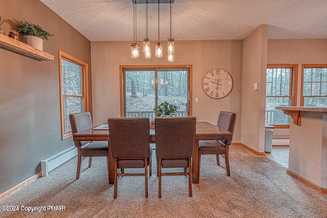 dining area with baseboards, light colored carpet, and a textured ceiling