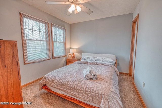 carpeted bedroom featuring a textured ceiling, baseboards, and a ceiling fan