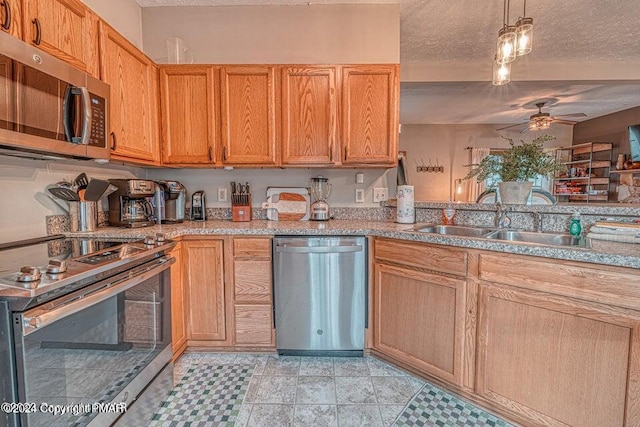 kitchen featuring light countertops, appliances with stainless steel finishes, a textured ceiling, a ceiling fan, and a sink