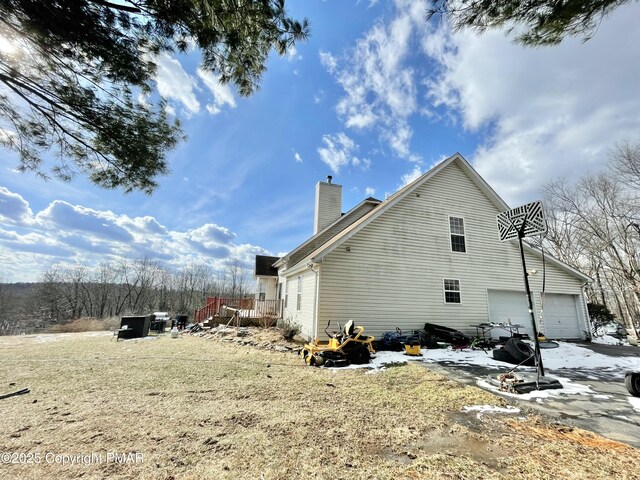 view of side of home featuring a garage and a deck