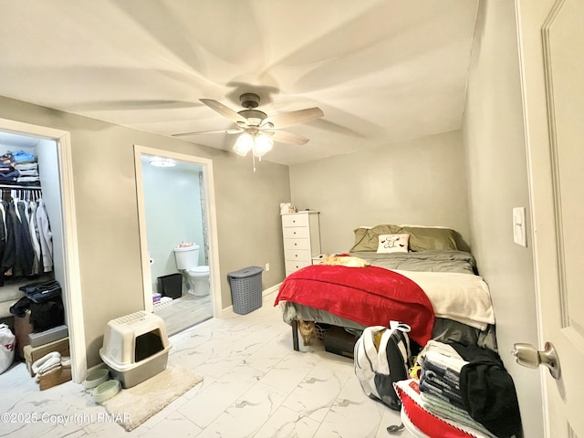 bedroom featuring ceiling fan, ensuite bath, and a closet