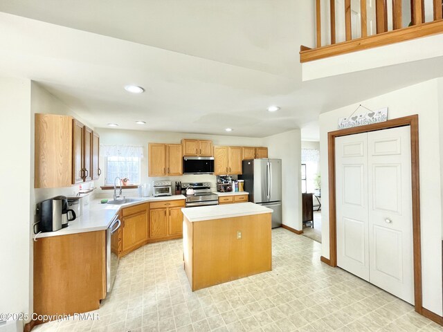 kitchen with appliances with stainless steel finishes, a center island, and sink