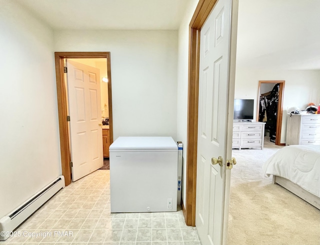 clothes washing area featuring baseboard heating and light carpet