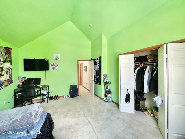 carpeted bedroom with high vaulted ceiling and a closet