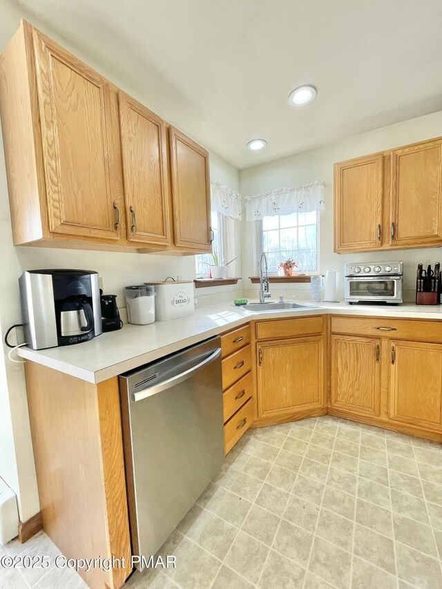 kitchen featuring sink, kitchen peninsula, and dishwasher