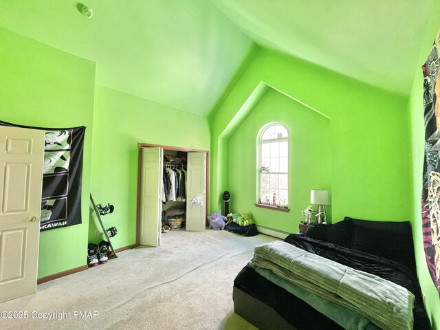 carpeted bedroom with vaulted ceiling, a closet, and baseboard heating