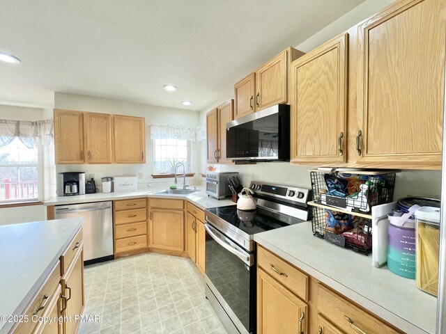 kitchen featuring light brown cabinetry, sink, and stainless steel appliances