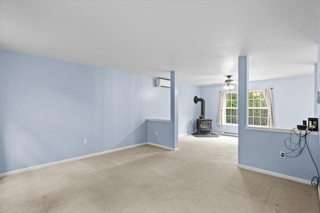 2615 Vista Dr, Blakeslee, PA 18610 - unfurnished living room featuring a wood stove, an AC wall unit, carpet, a baseboard heating unit, and ceiling fan