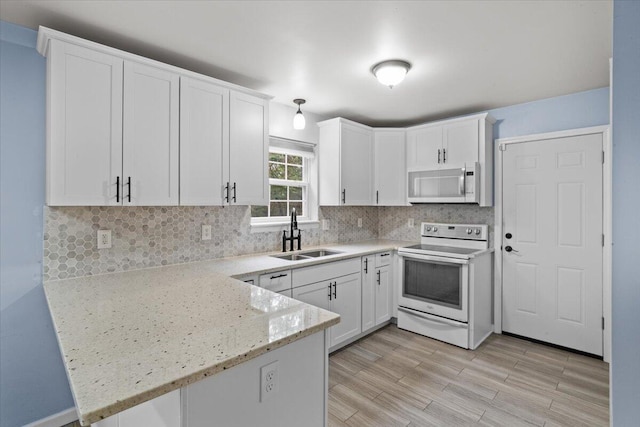 2615 Vista Dr, Blakeslee, PA 18610 - kitchen featuring white appliances, a peninsula, decorative backsplash, and white cabinetry
