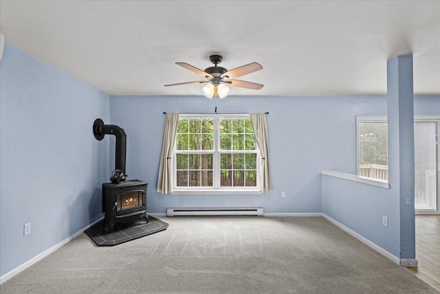 2615 Vista Dr, Blakeslee, PA 18610 - unfurnished living room featuring a baseboard heating unit, healthy amount of natural light, a wood stove, and ceiling fan