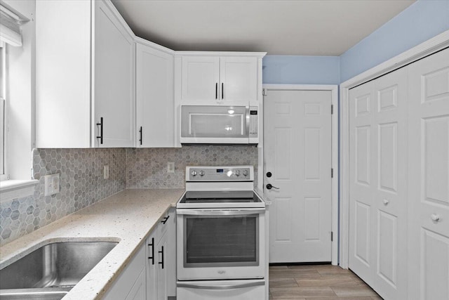 2615 Vista Dr, Blakeslee, PA 18610 - kitchen with white appliances, white cabinets, tasteful backsplash, light wood finished floors, and light stone counters