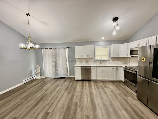 1223 Coolbaugh Rd, East Stroudsburg, PA 18302 - kitchen with appliances with stainless steel finishes, a sink, lofted ceiling, a baseboard radiator, and tasteful backsplash