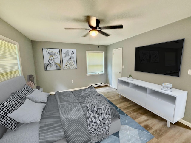 1223 Coolbaugh Rd, East Stroudsburg, PA 18302 - bedroom featuring baseboard heating, baseboards, a ceiling fan, and wood finished floors