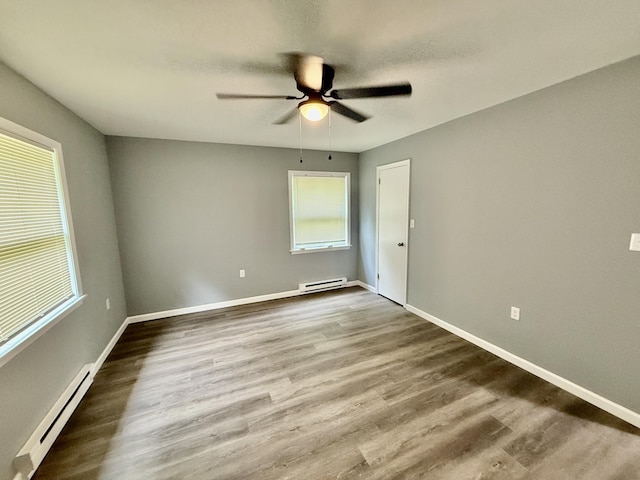 1223 Coolbaugh Rd, East Stroudsburg, PA 18302 - spare room featuring a baseboard radiator, baseboard heating, a ceiling fan, wood finished floors, and baseboards