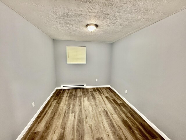 1223 Coolbaugh Rd, East Stroudsburg, PA 18302 - spare room with wood finished floors, a baseboard radiator, baseboards, and a textured ceiling