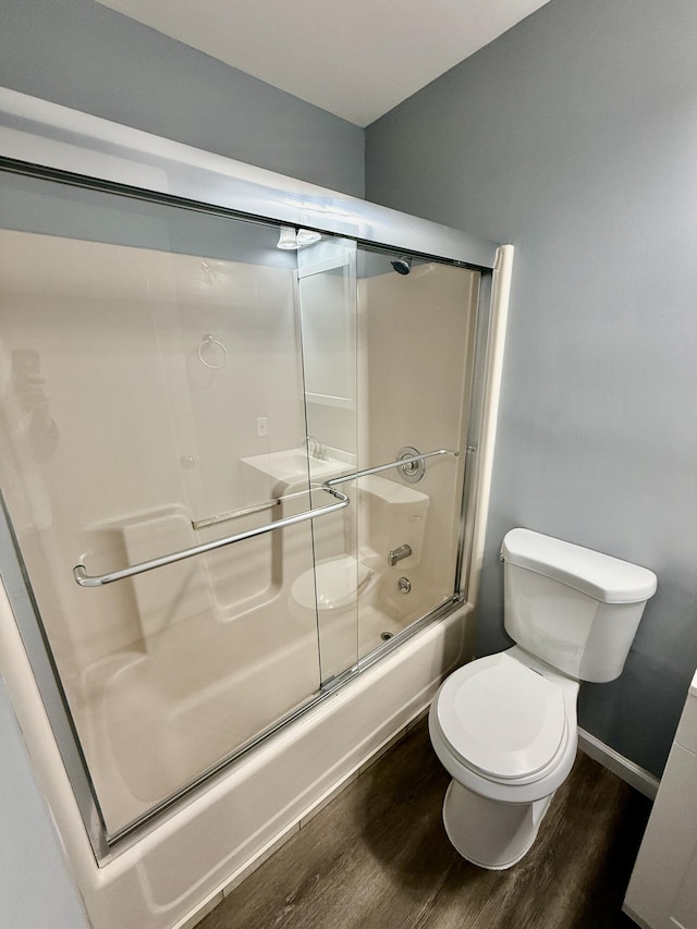1223 Coolbaugh Rd, East Stroudsburg, PA 18302 - full bath featuring wood finished floors, toilet, combined bath / shower with glass door, and baseboards