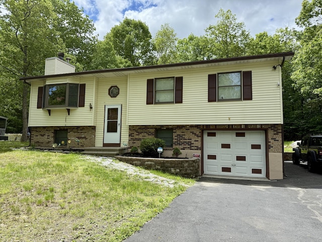 1223 Coolbaugh Rd, East Stroudsburg, PA 18302 - split foyer home featuring brick siding, an attached garage, a chimney, driveway, and a front yard