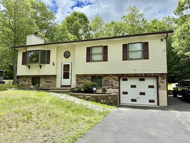 1223 Coolbaugh Rd, East Stroudsburg, PA 18302 - raised ranch with brick siding, a chimney, a garage, and driveway