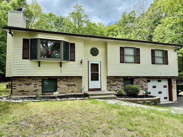 1223 Coolbaugh Rd, East Stroudsburg, PA 18302 - split foyer home with a garage, brick siding, a chimney, driveway, and a front yard