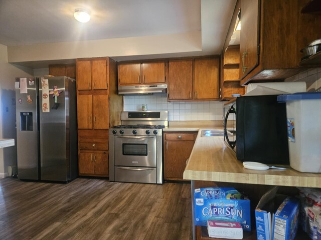 159 Summit Ave, Pocono Summit, PA 18346 - kitchen with appliances with stainless steel finishes, open shelves, under cabinet range hood, brown cabinets, and dark wood-style flooring