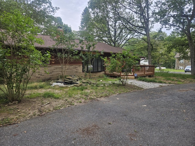 159 Summit Ave, Pocono Summit, PA 18346 - view of front of house featuring brick siding, a deck, a chimney, and a shingled roof