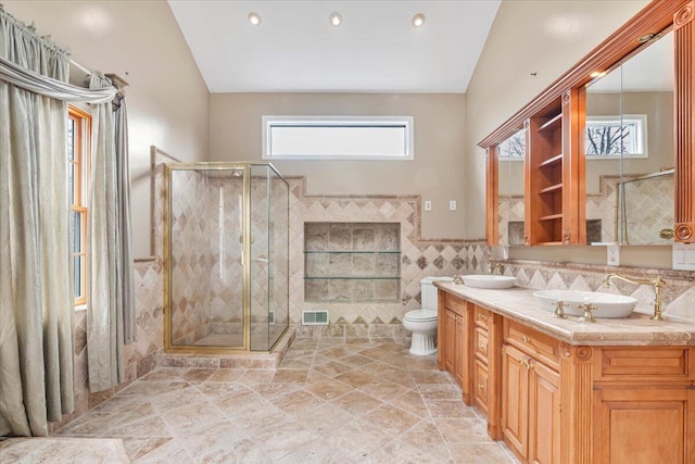 bathroom featuring a shower stall, visible vents, toilet, vaulted ceiling, and tile walls