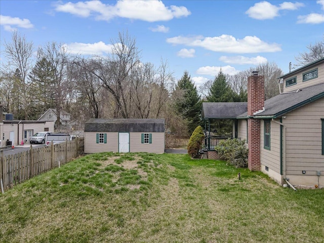 view of yard with an outbuilding, a storage shed, and fence