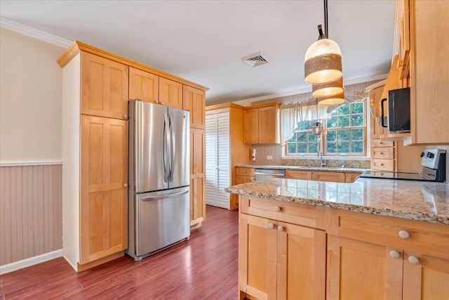 kitchen with wood finished floors, light brown cabinetry, appliances with stainless steel finishes, ornamental molding, and visible vents