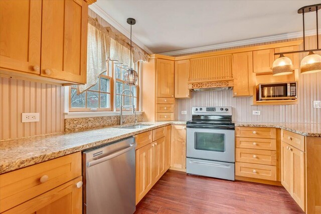 kitchen with appliances with stainless steel finishes, light stone counters, light brown cabinets, and a sink