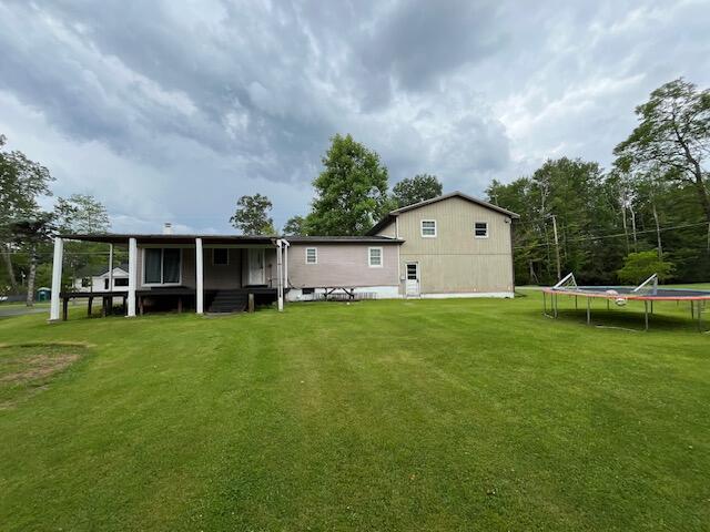 501 Lake Spangenberg Rd, Jefferson Township, PA 18436 - rear view of house with a trampoline and a lawn