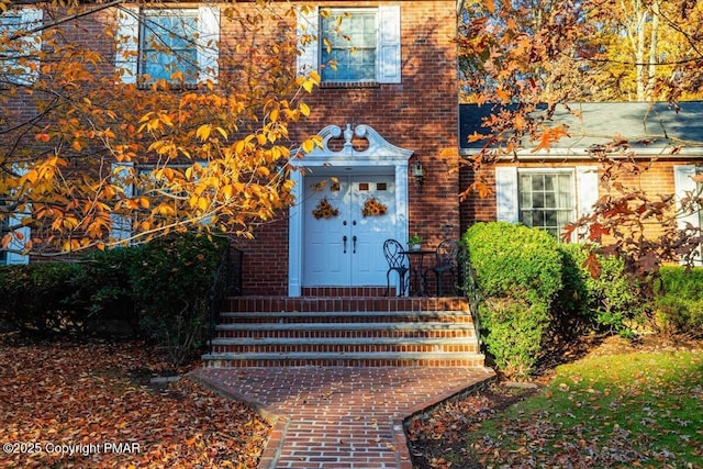 entrance to property featuring brick siding