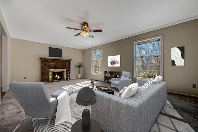 living area featuring crown molding, carpet, a brick fireplace, and ceiling fan