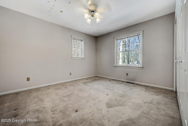 carpeted empty room featuring baseboards and a ceiling fan