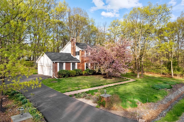 127 Ladderback Ln, Cresco, PA 18326 - view of front of property featuring brick siding, asphalt driveway, a chimney, a front lawn, and an attached garage