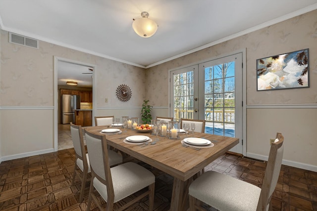 dining space featuring french doors, visible vents, crown molding, baseboards, and wallpapered walls