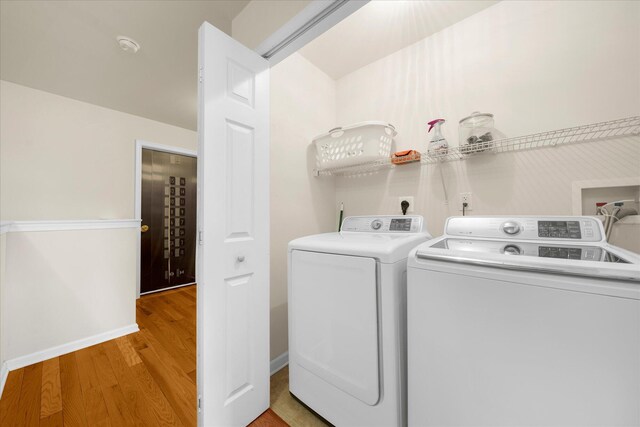 laundry area featuring laundry area, separate washer and dryer, and light wood-type flooring