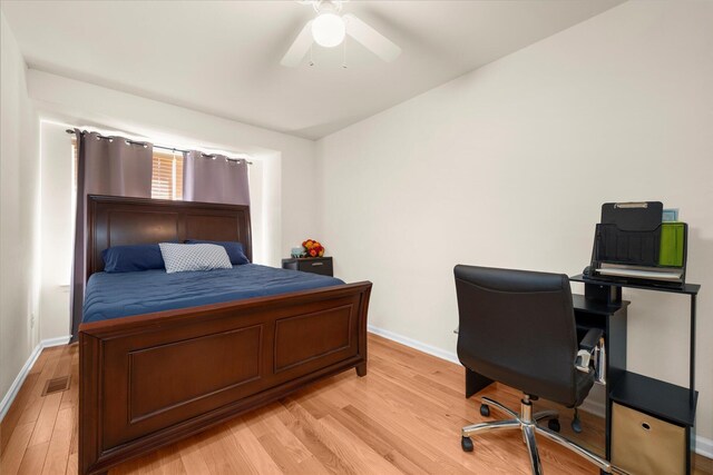bedroom with baseboards, visible vents, ceiling fan, and light wood finished floors