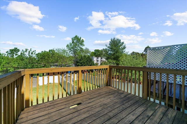 wooden terrace featuring a lawn and a fenced backyard