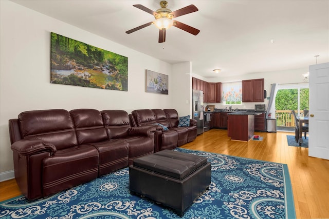 living room with light wood-type flooring and ceiling fan
